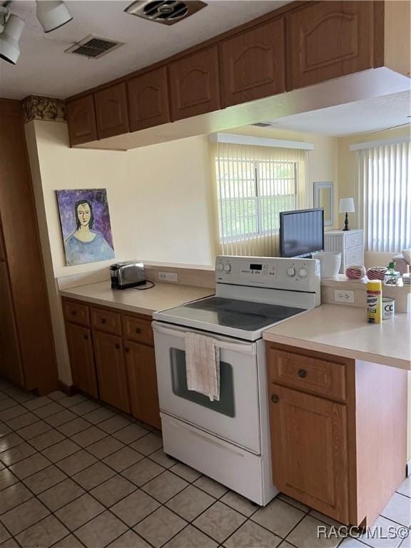 13 N Wadsworth Ave, Beverly Hills, FL 34465 - kitchen with white electric range oven, light tile patterned floors, and light countertops