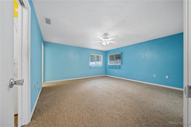 spare room with a textured ceiling, ceiling fan, and carpet flooring