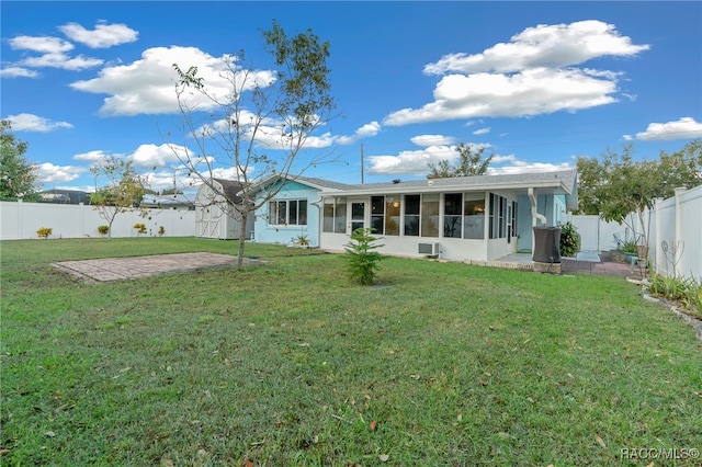 back of property featuring a patio area, a sunroom, and a lawn