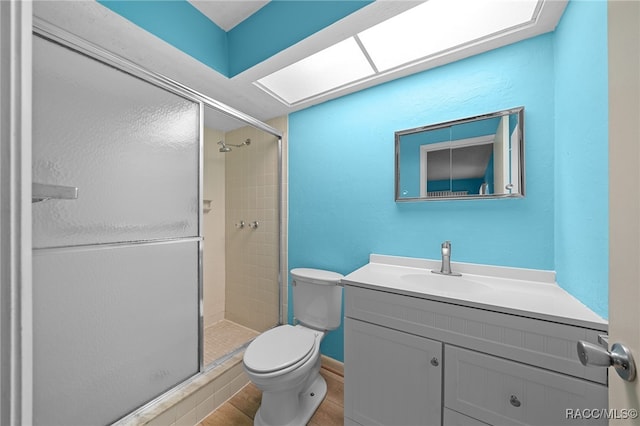 bathroom with toilet, walk in shower, and vanity