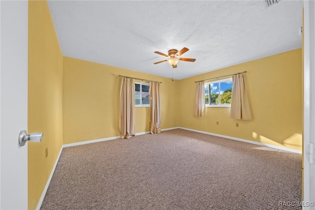 carpeted spare room featuring ceiling fan and a textured ceiling