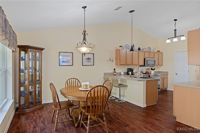 dining area featuring dark hardwood / wood-style flooring and vaulted ceiling