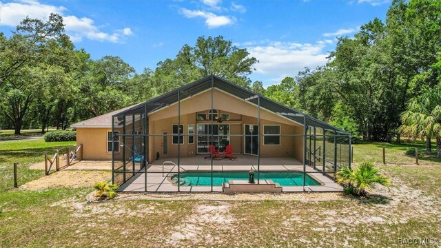8583 N Tibet Ter, Dunnellon, FL 34433 - back of property featuring a patio area, stucco siding, an outdoor pool, and glass enclosure