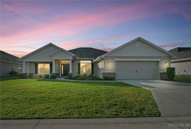 view of front of home with a garage and a lawn