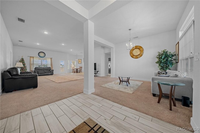 living room with light colored carpet and a notable chandelier