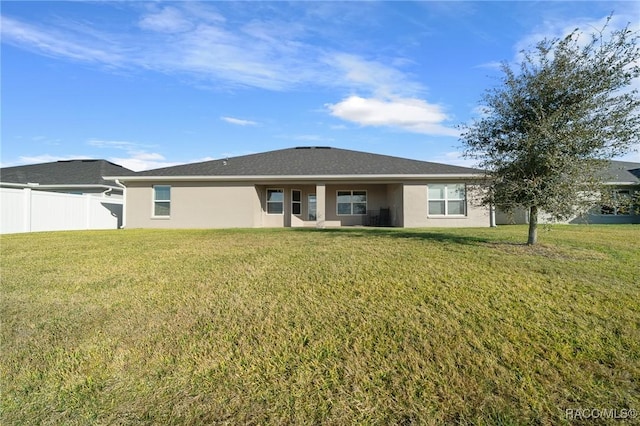 rear view of property featuring a lawn