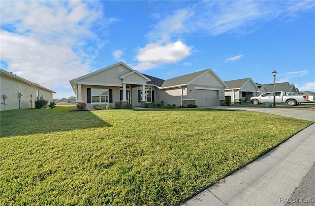 ranch-style home featuring a garage, covered porch, and a front yard