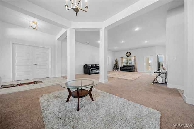 living room with light carpet, a chandelier, and decorative columns