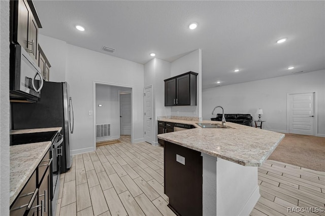 kitchen featuring a kitchen breakfast bar, light stone countertops, range with electric cooktop, and sink