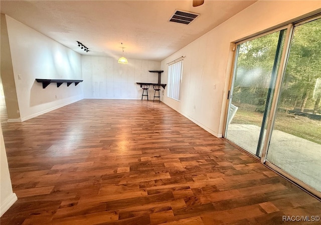 interior space featuring a textured ceiling and dark wood-type flooring