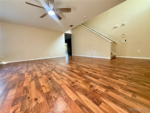 unfurnished living room featuring hardwood / wood-style flooring, vaulted ceiling, and ceiling fan