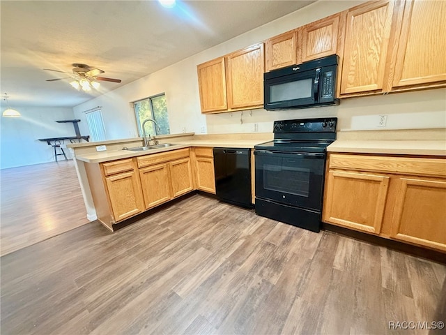 kitchen featuring kitchen peninsula, light wood-type flooring, ceiling fan, sink, and black appliances