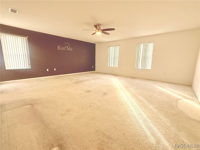 carpeted spare room with ceiling fan