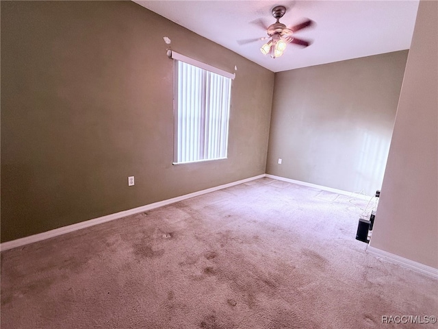 carpeted spare room featuring ceiling fan