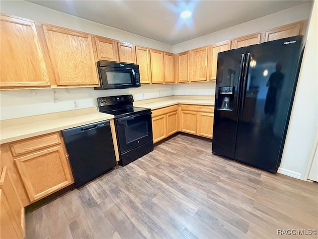 kitchen with light hardwood / wood-style flooring, black appliances, and light brown cabinets