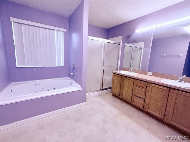 bathroom featuring plus walk in shower, vanity, and a textured ceiling