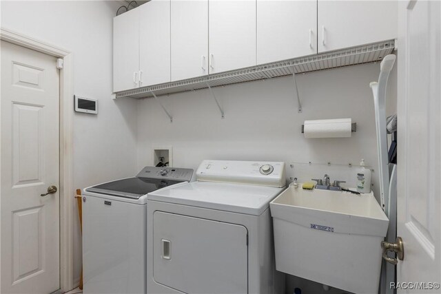 21312 Preservation Drive, Central Pasco, FL 34638 - laundry room featuring washer and dryer and cabinet space