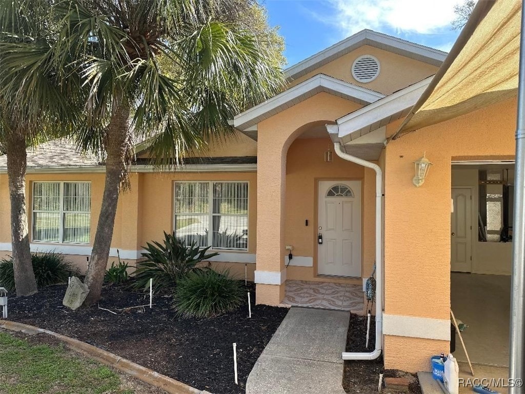 view of exterior entry featuring stucco siding