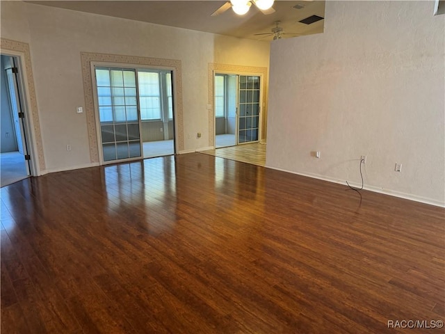 empty room with ceiling fan and dark wood-type flooring