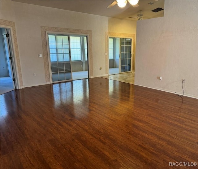 empty room featuring ceiling fan and dark hardwood / wood-style flooring