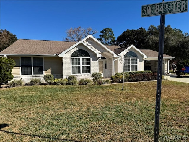 ranch-style house featuring a garage and a front lawn