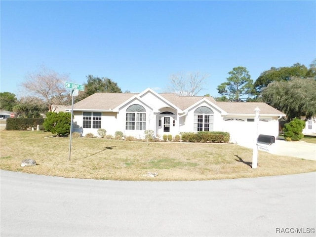 ranch-style house with a garage and a front lawn