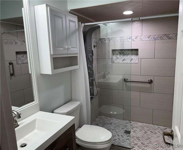 bathroom with vanity, toilet, and a tile shower