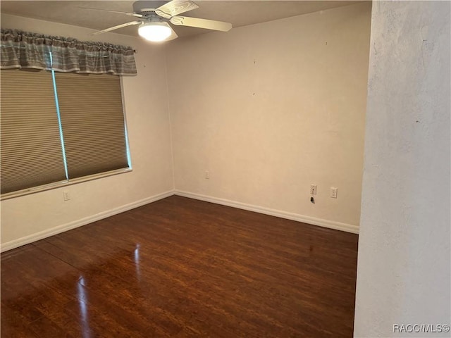 empty room with ceiling fan and dark wood-type flooring