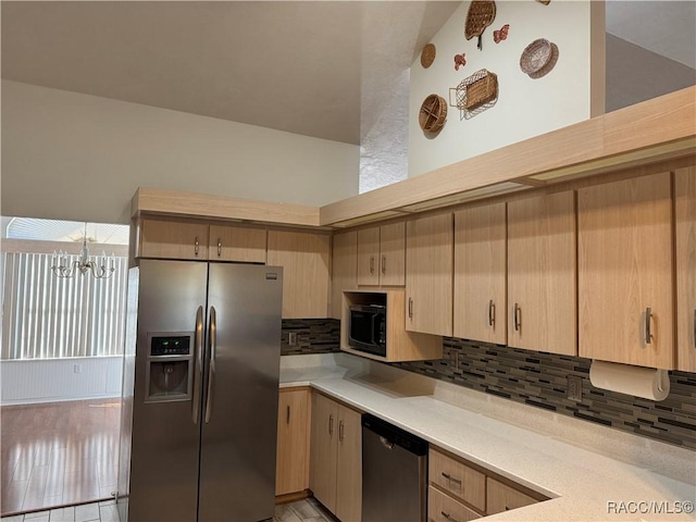 kitchen featuring light brown cabinetry, backsplash, appliances with stainless steel finishes, and a chandelier