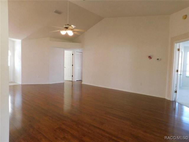 empty room with ceiling fan, dark hardwood / wood-style floors, and vaulted ceiling