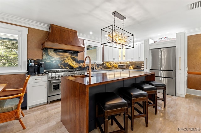 kitchen with tasteful backsplash, custom range hood, stainless steel appliances, white cabinets, and a kitchen island