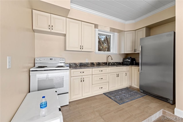 kitchen with stainless steel refrigerator, sink, dark stone countertops, and white electric range