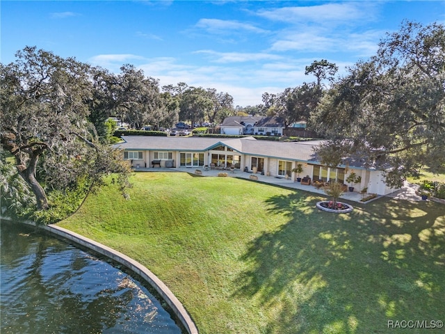 rear view of property with a yard and a water view