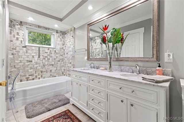 bathroom featuring tiled shower / bath, vanity, and ornamental molding