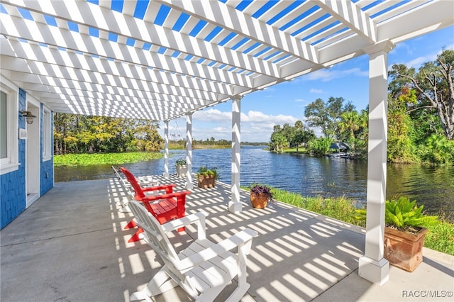 view of patio / terrace with a pergola and a water view