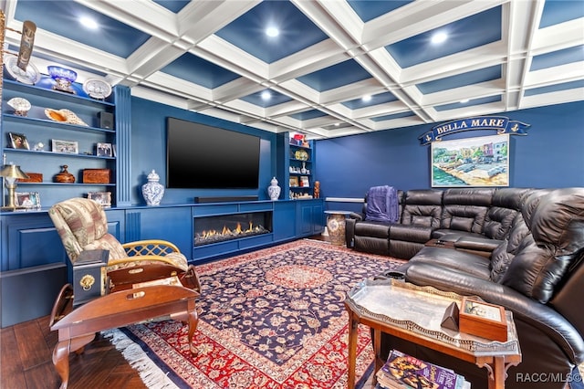 home theater featuring hardwood / wood-style floors, coffered ceiling, ornamental molding, built in features, and beam ceiling