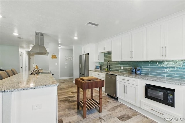 42 Magnolia Ave, Yankeetown, FL 34498 - kitchen featuring stainless steel appliances, island range hood, light wood finished floors, white cabinetry, and recessed lighting