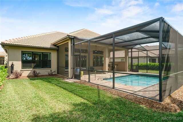 back of property featuring a patio area, stucco siding, a tiled roof, an outdoor pool, and a yard
