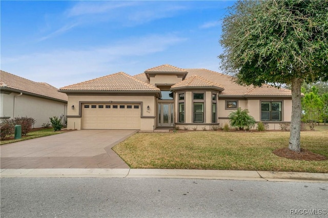 mediterranean / spanish house featuring a garage and a front yard