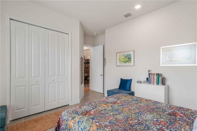 bedroom with light tile patterned floors and a closet