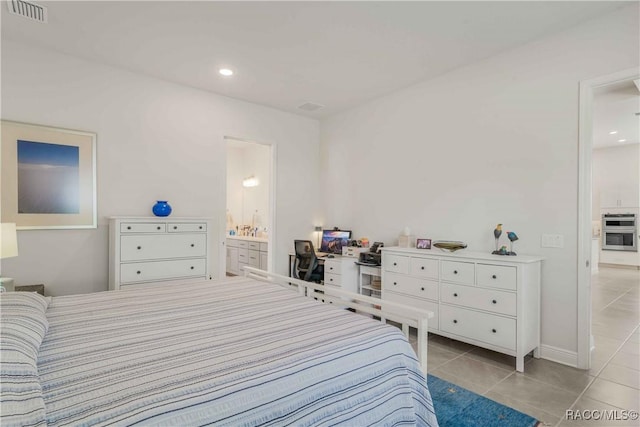 bedroom with ensuite bath and light tile patterned floors