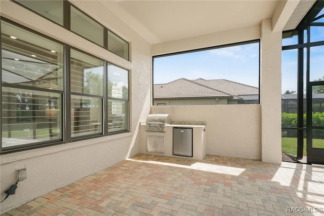 unfurnished sunroom with a textured wall and brick floor