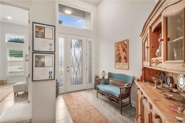 tiled foyer with a towering ceiling and plenty of natural light