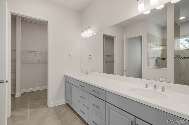 bathroom with double vanity, a sink, tile patterned floors, and a walk in shower