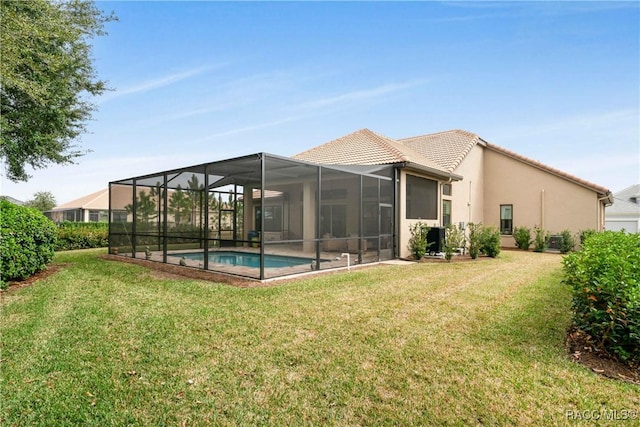 rear view of property featuring a yard and a lanai