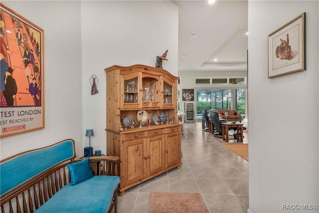 interior space with a raised ceiling and light tile patterned floors