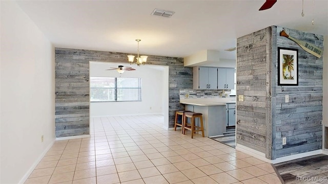 125 W Seymeria Dr, Beverly Hills, FL 34465 - kitchen with a ceiling fan, a chandelier, a kitchen breakfast bar, and light tile patterned floors