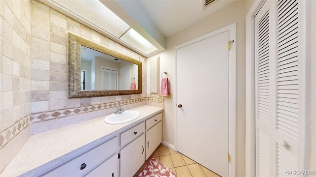125 W Seymeria Dr, Beverly Hills, FL 34465 - bathroom with a closet, vanity, tile patterned flooring, and decorative backsplash