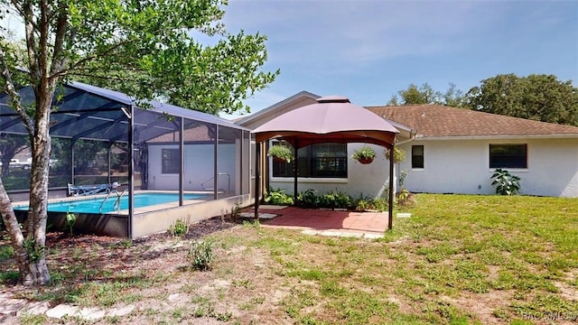 125 W Seymeria Dr, Beverly Hills, FL 34465 - back of house with a gazebo, stucco siding, an outdoor pool, a lawn, and a patio area