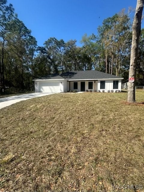 view of front of home featuring a garage, concrete driveway, and a front lawn